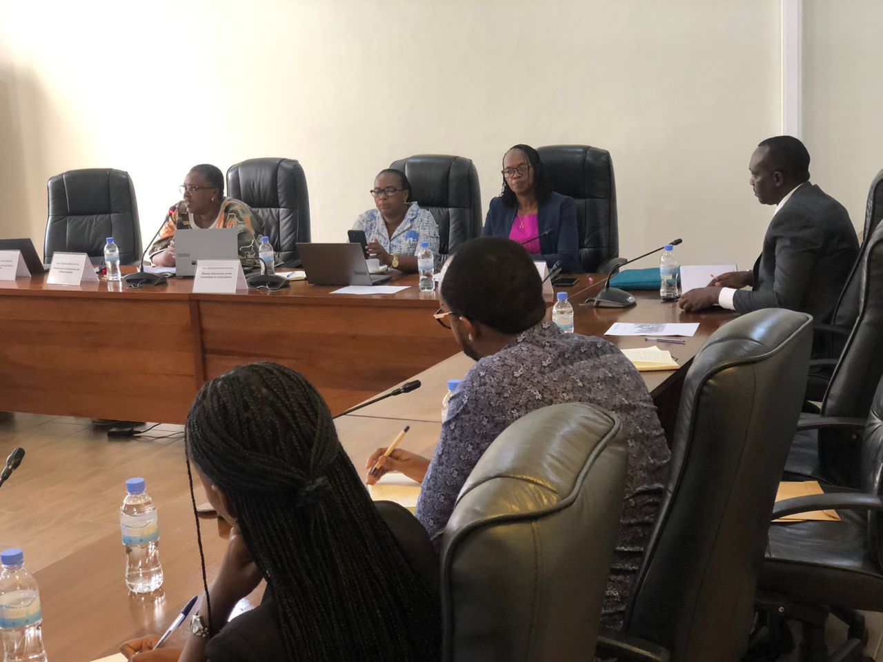GFA representatives at a committee-room policy session with government officials seated behind nameplates.